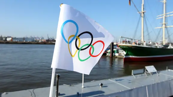 A flag with the Olympic rings hangs in the port of Hamburg