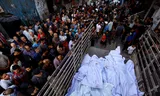 Mourners gather around the bodies of members of the Abu Dalal family, who aid workers say were killed in an Israeli airstrike on their home overnight in Nuseirat, central Gaza Strip, on October 29, 2025. 