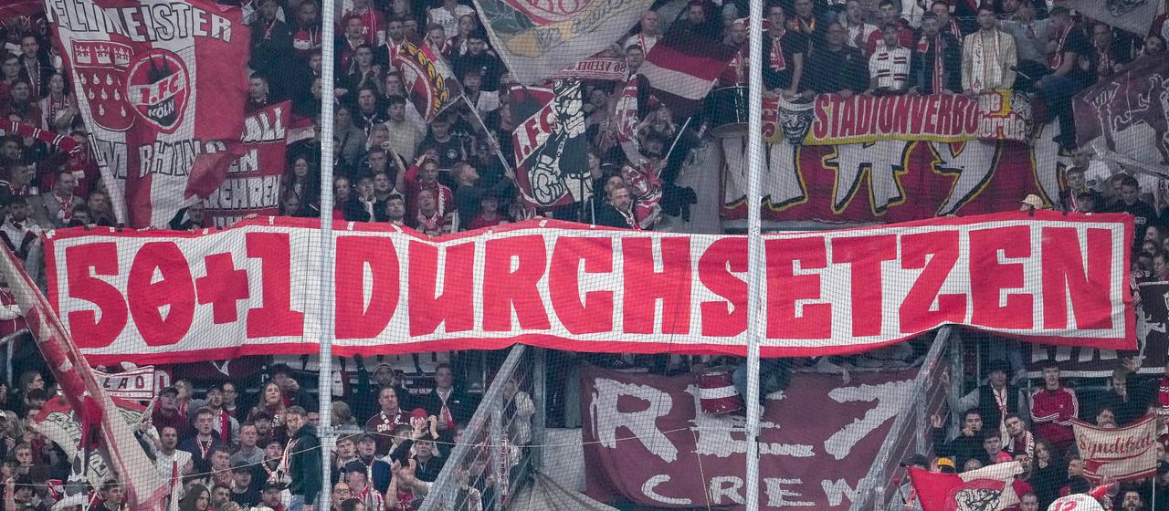 The fans of 1. FC Köln show a banner about the 50+1 rule in the fan curve