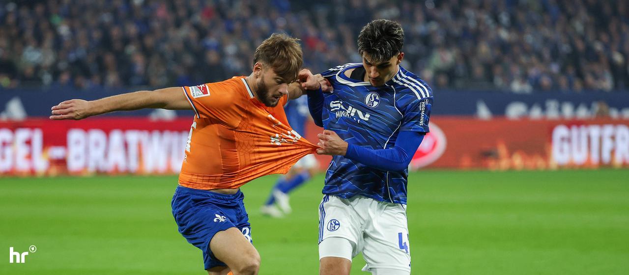 Holding the jerseys: Darmstadt's Killian Corredor (left) in a duel with Schalke's Mertcan Ayhan.
