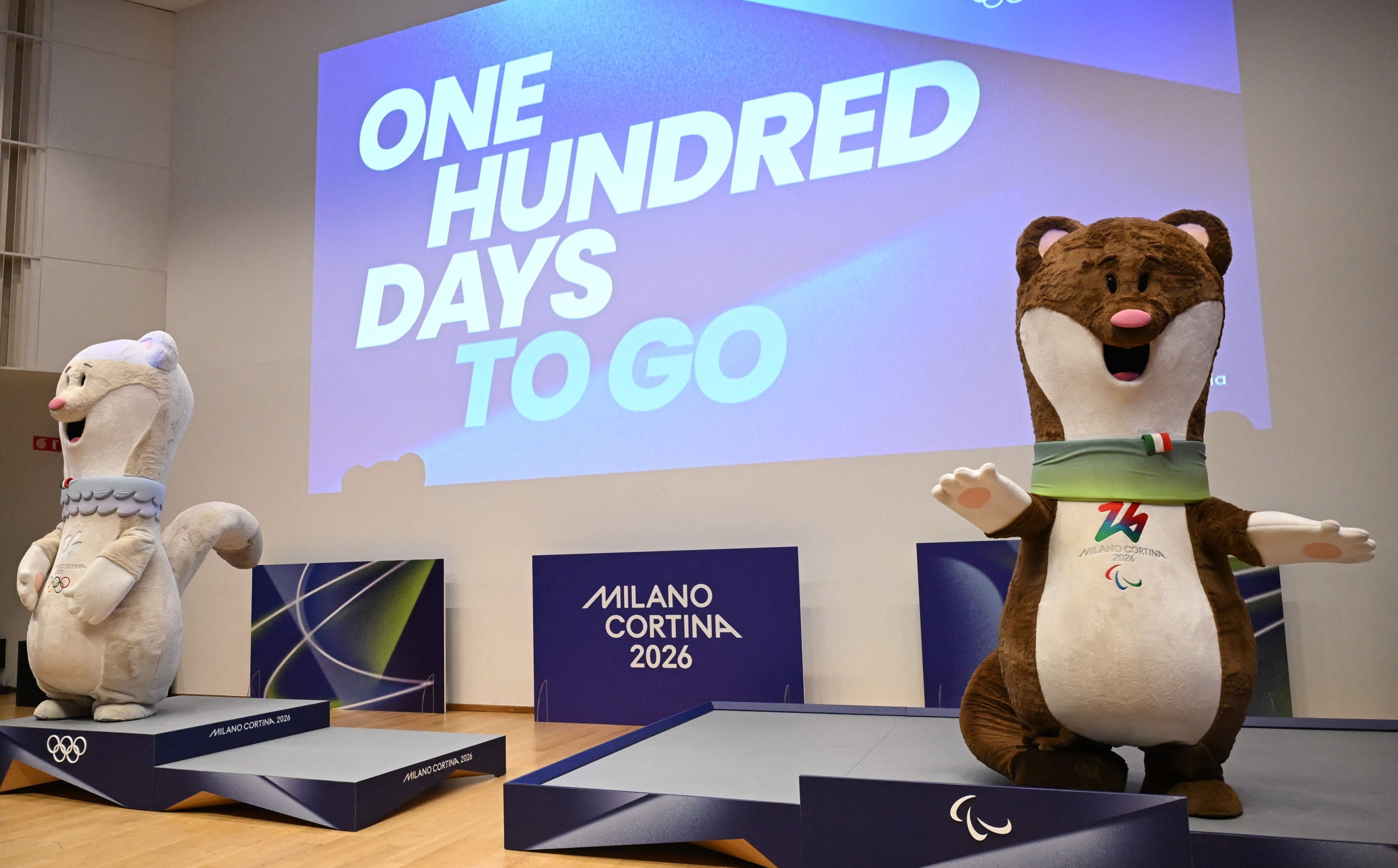 The Olympic mascots Tina (L) and Milo pose on the podiums of the Milano Cortina 2026 Olympic and Paralympic Games during a press conference marking 100 days to go before the start of the games, in Milan on October 29, 2025. (Photo by PIERO CRUCIATTI / AFP)