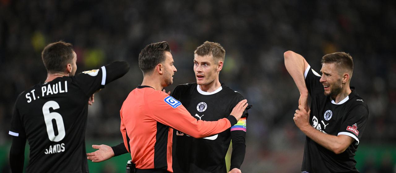 St. Pauli's Eric Smith and Karol Mets protest to the referee