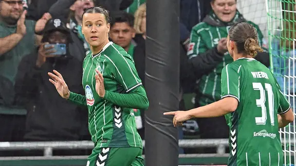 Bremen's Larissa Mühlhaus (l.) raises her arms.