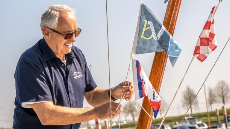 A boat owner attaches the Biesbosch Vaantje to his mast in the Drimmelen marina (photo: Biesbosch Vaantje Foundation)