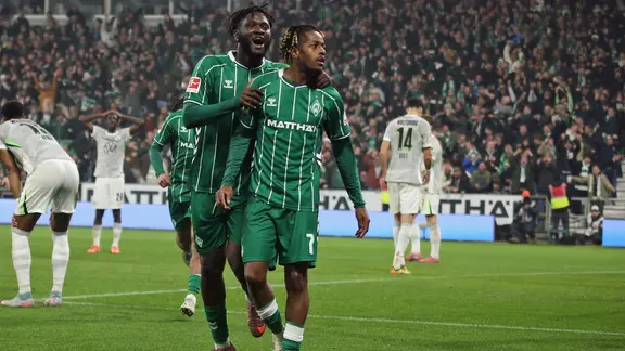 Bremen's Samuel Mbangula (m.) celebrates his goal
