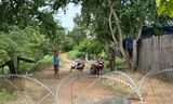 The village of Nong Chan in the Thailand-Cambodia border region has been surrounded by soldiers and barriers after a conflict over the border escalated in the summer. The photo was taken from a Thai military cordon. Showing are Cambodian villagers and a Cambodian soldier. 