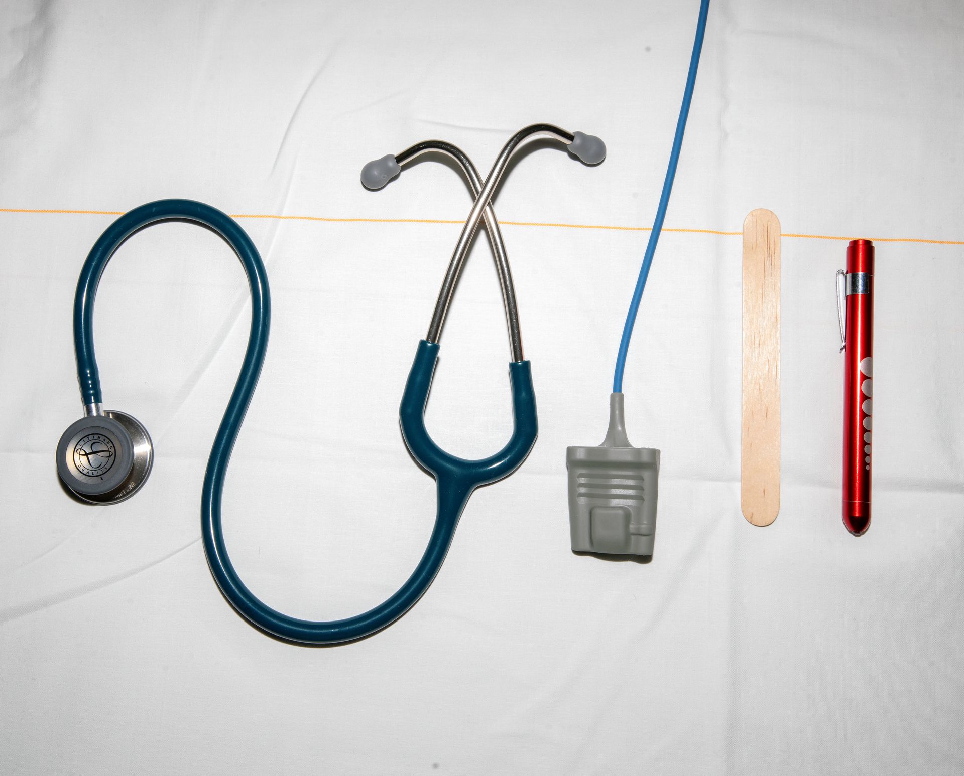 Medical instruments including a stethoscope, an oxygen saturator, a tongue depressor and a pen.
