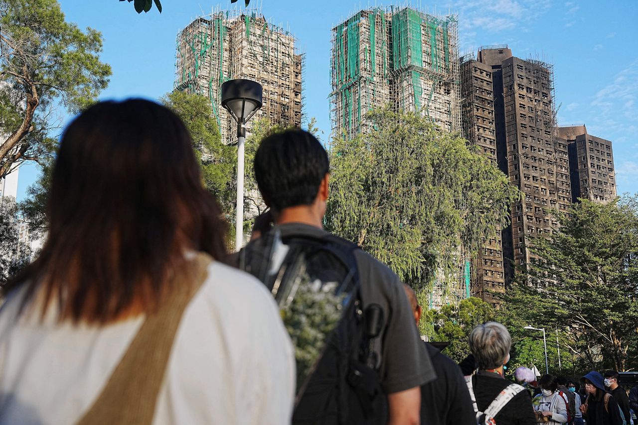 Hong Kongers are standing in long lines this weekend to lay flowers at a spontaneously created memorial in a park near the affected apartment buildings.