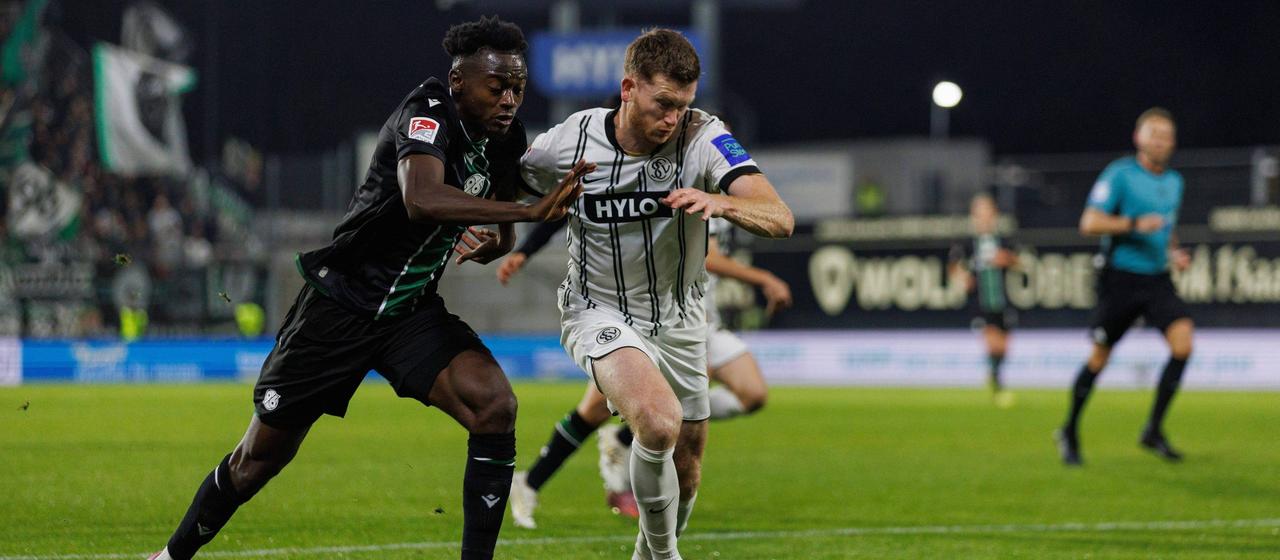 Hanover's Mustapha Bundu in a duel with Florian Le Joncour from Elversberg