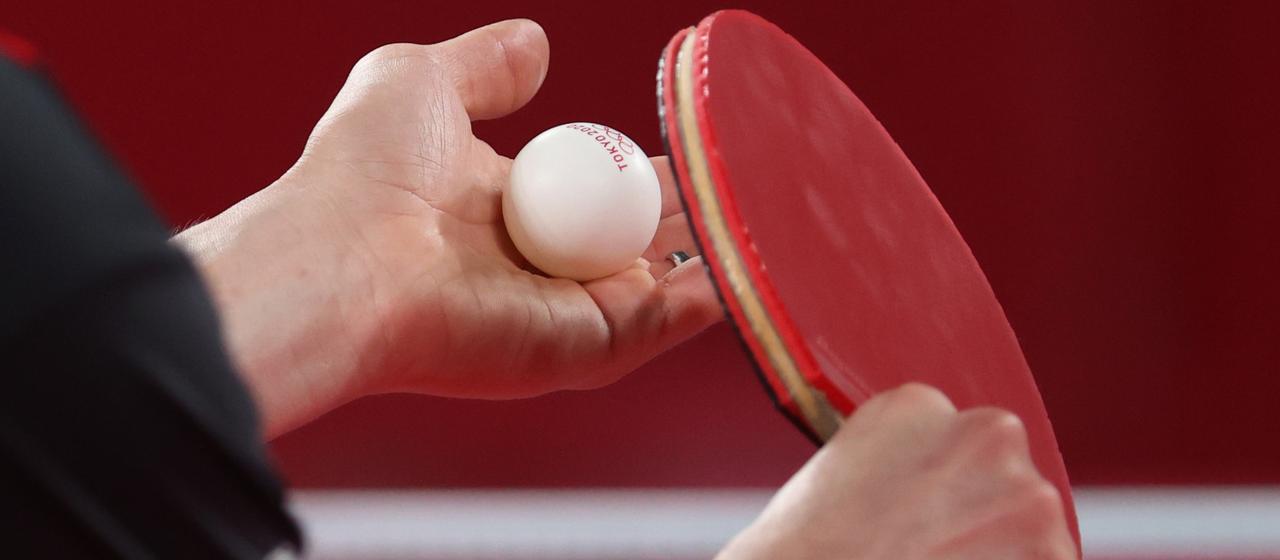 Hands with table tennis ball and racket 
