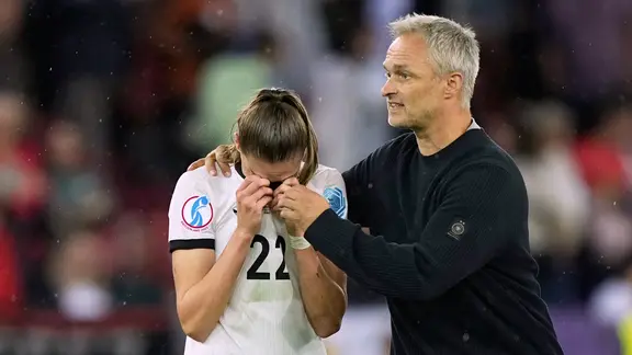 National coach Christian Wück comforts Jule Brand