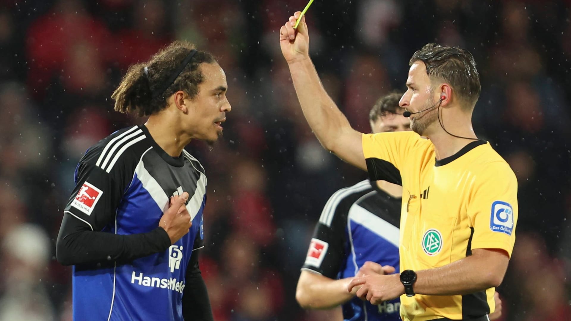 Yussuf Poulsen (l.) sees the yellow card from referee Daniel Schlager: Hamburger SV ended the game with nine men.