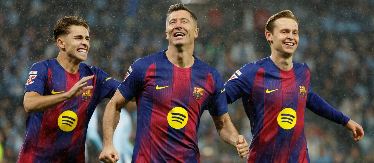 Barcelona's Robert Lewandowski (m.) celebrates his goal to make it 0-1 with teammates Fermin Lopez (l.) and Frenkie de Jong