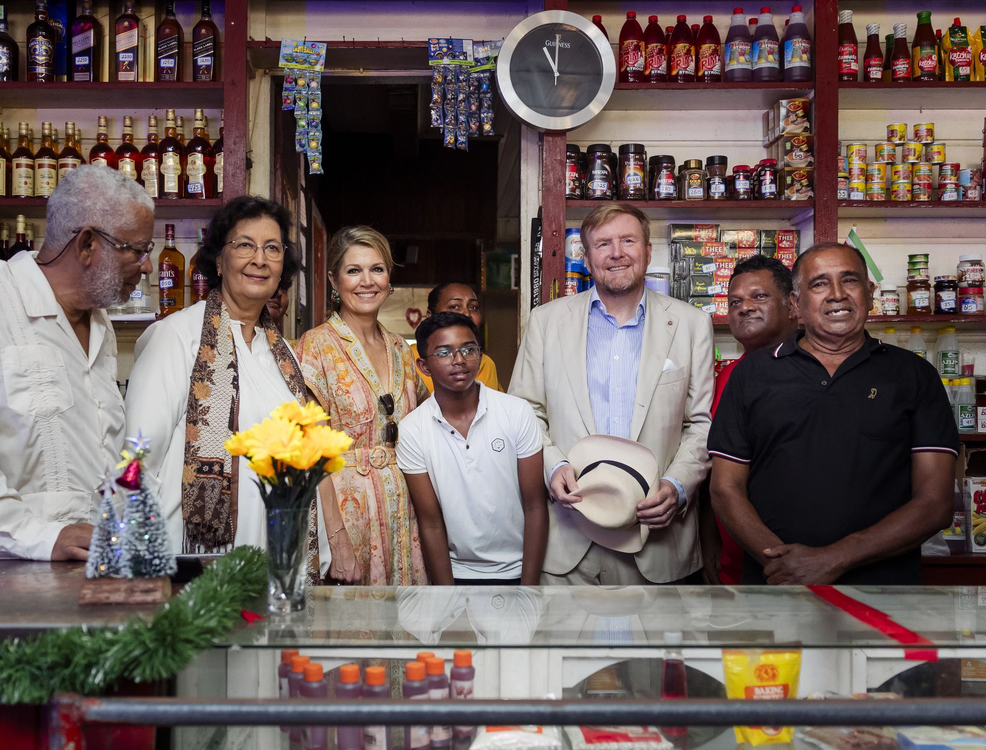 King Willem-Alexander and Queen Máxima together with Surinamese President Jennifer Geerlings-Simons and her husband (left) the Robby Jwelal store (right).  