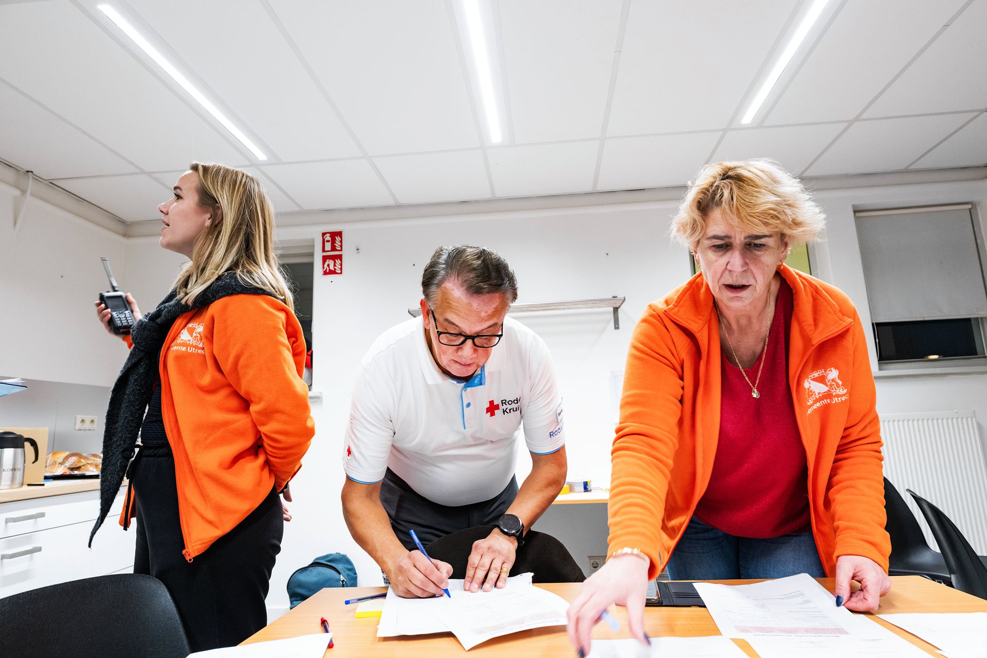 Marleen Lubberdink (left), a Red Cross volunteer and a municipal colleague, pass on emergency notifications to the fire brigade and city hall during the exercise.