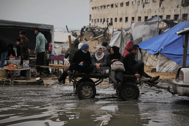 Palestinians ride on a cart through the flooded streets.