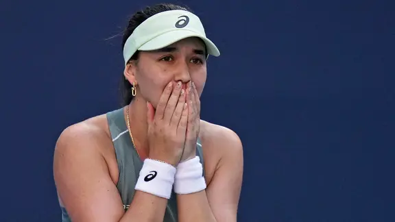 Eva Lys covers her face with her hands in joy