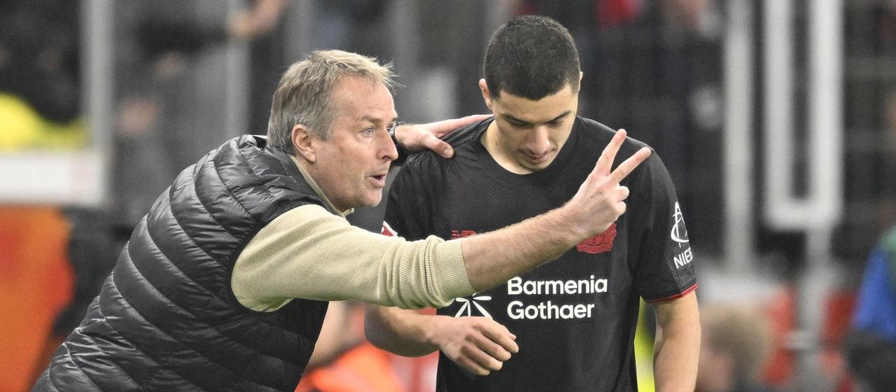 Leverkusen coach Kasper Hjulmand talks to Ibrahim Maza on the sidelines