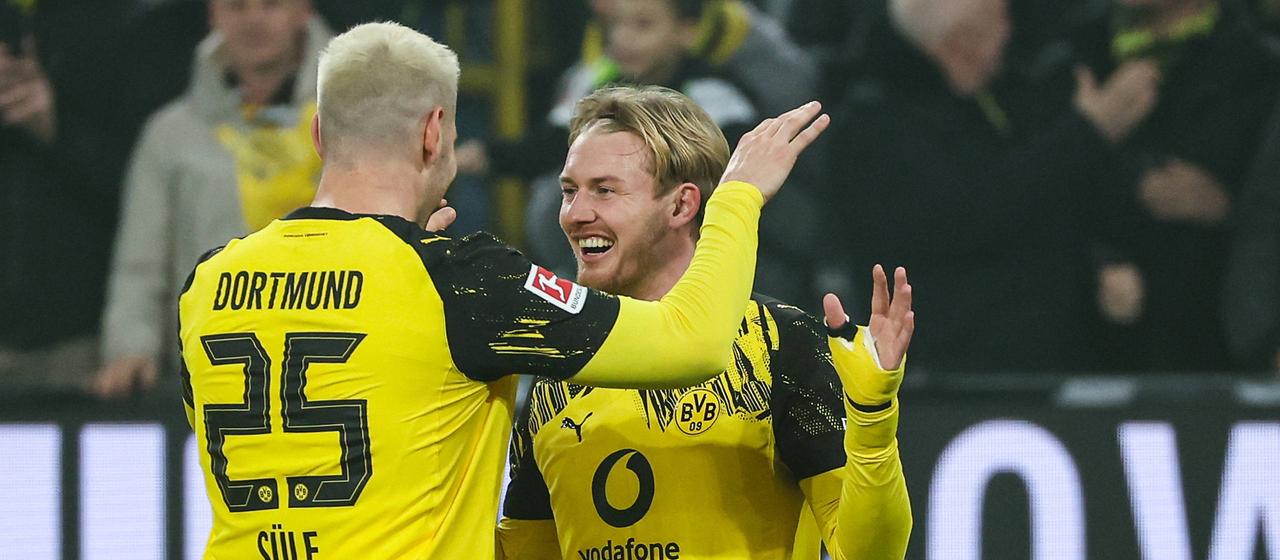 Dortmund's goalscorer Julian Brandt is high-fived by teammate Niklas Süle