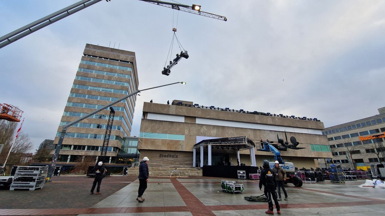 Trusses with lamps are placed on the roof of the town hall using a large crane