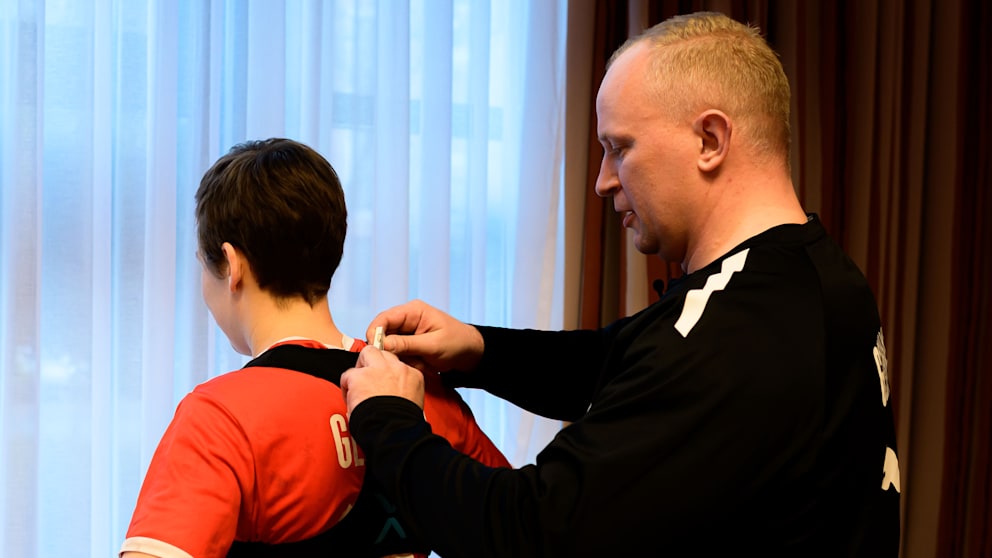 Dr. Simon Overkamp schnallt Nationalspielerin Alina Grijseels die Weste mit dem Daten-Chip um