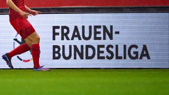 The logo of the women's football Bundesliga on an advertising board