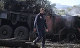 A firefighter passes a burned-out military vehicle at La Carlota air base in Caracas after the nighttime US attack on Venezuela. 