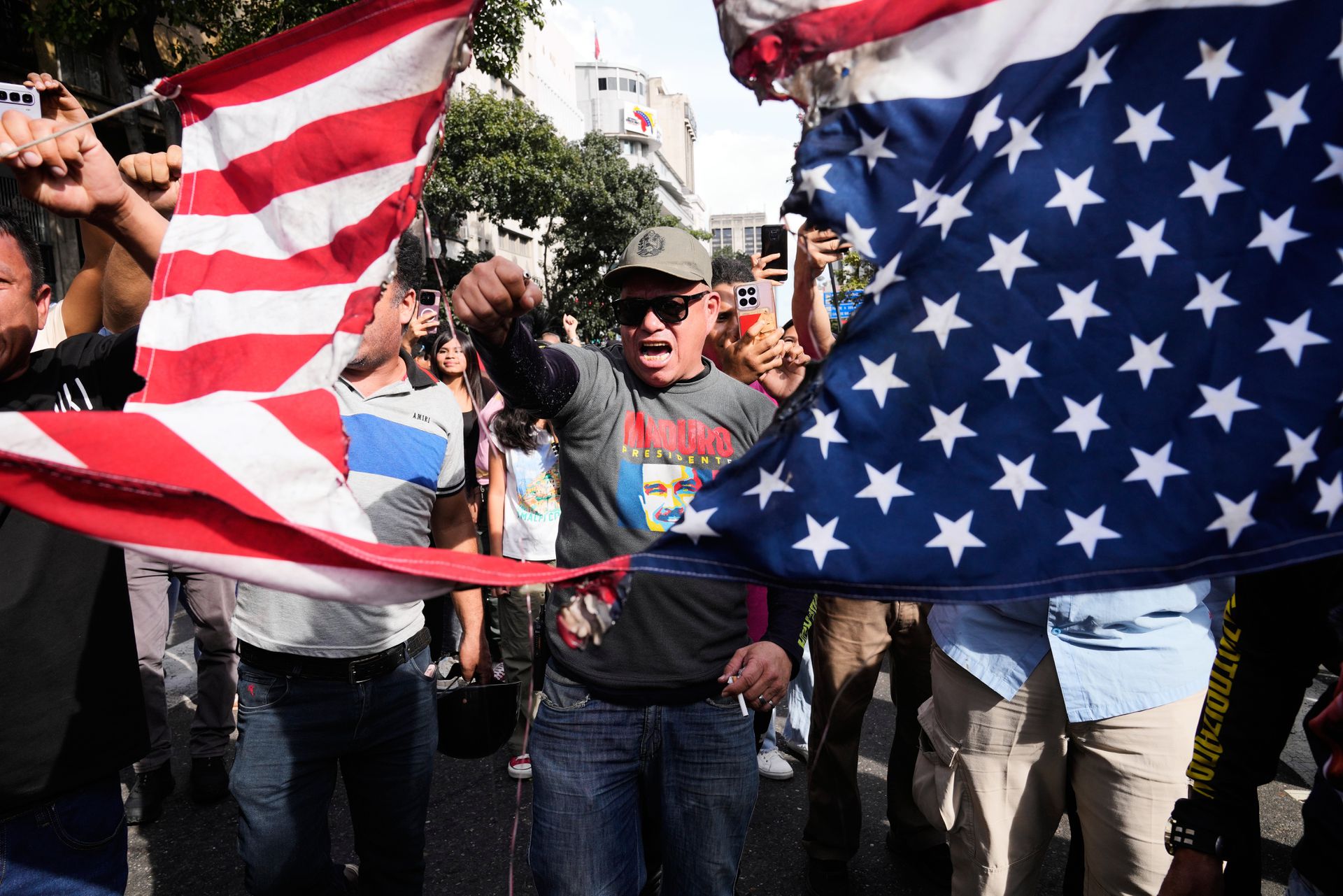 Maduro supporters cut an American flag in half in Caracas, the capital of Venezuela.