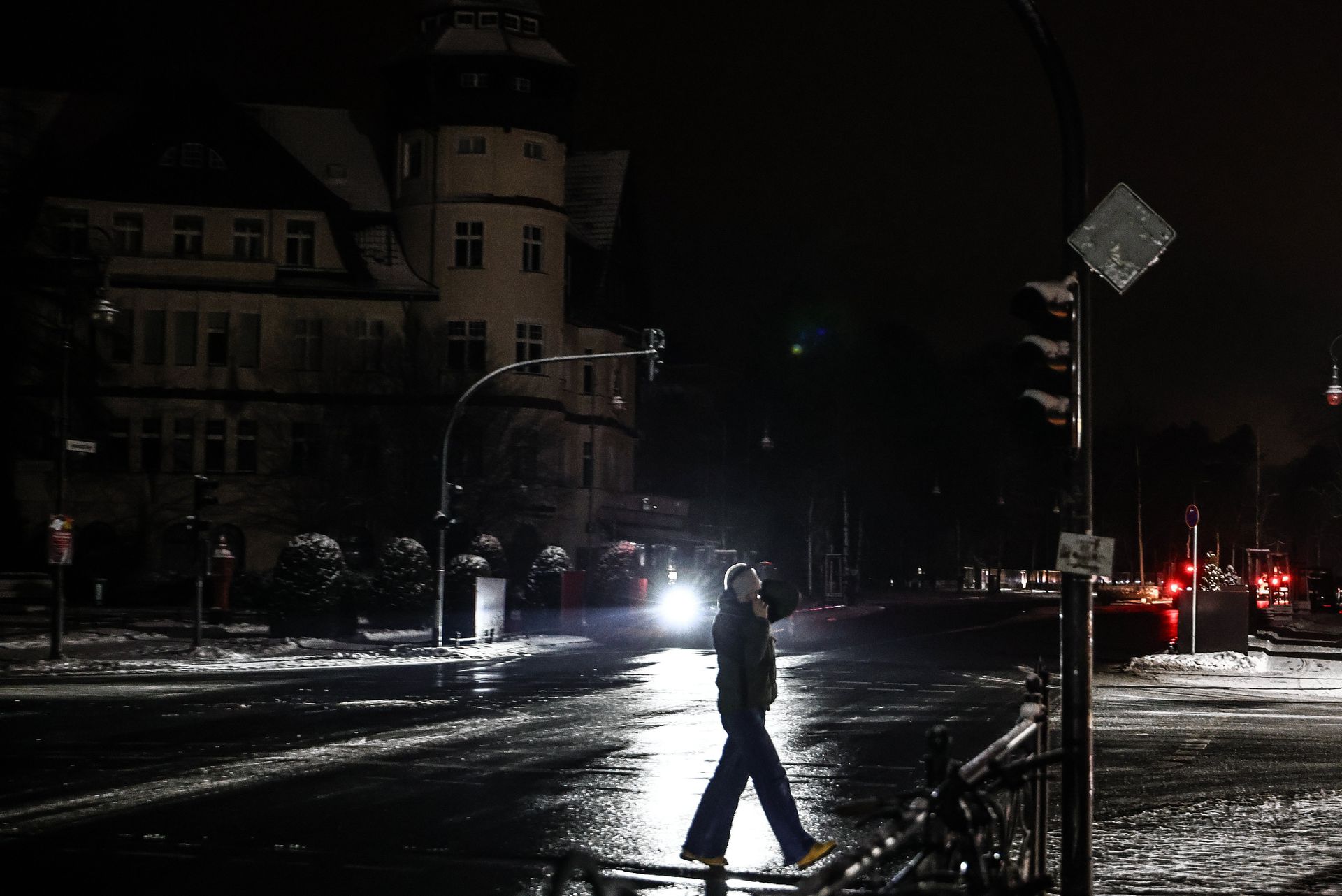 A pedestrian walks through a dark street in the Zehlendorf district of southwestern Berlin on Sunday during a large-scale power outage.