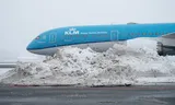 A KLM plane in the snow at Schiphol.