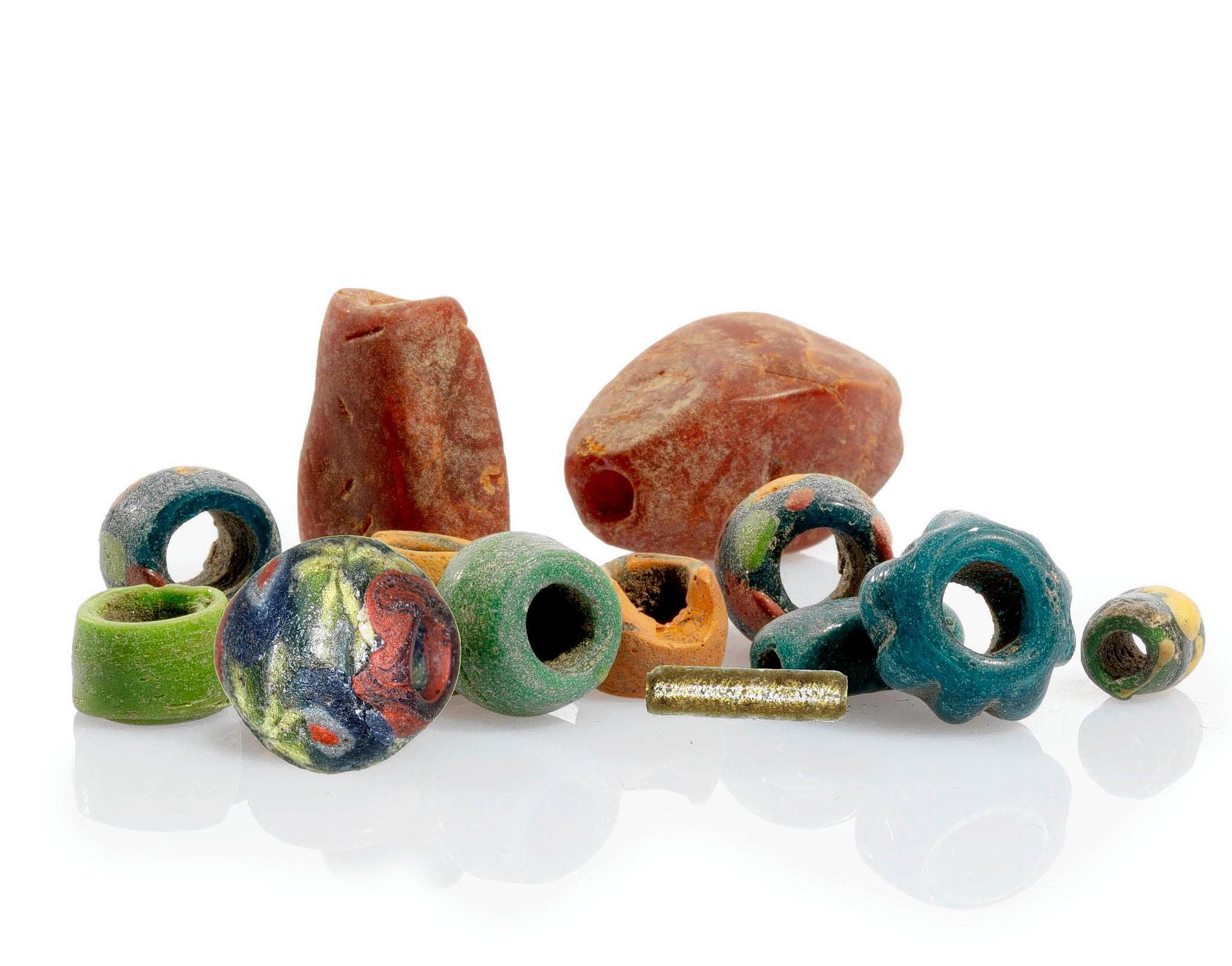 An impression of the variety of beads found in graves from the early Middle Ages. For example, amber from the Baltic Sea region (back) and so-called millefiori bead from Egypt (front left).