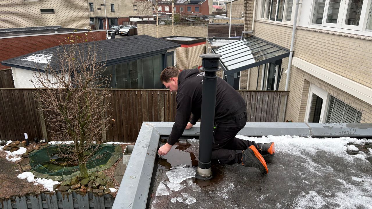 Roofer Verhoeven examines a leak on a flat roof (Photo: Imke van de Laar)
