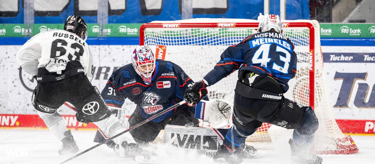 DEL professional Patrick Russell (l.) from the Kölner Haien shoots at the goal during the game in Nuremberg