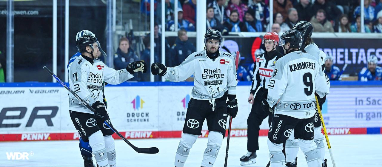 The Kölner Haie players celebrate a goal against the Dresden Eislöwen.