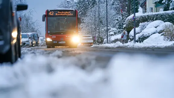 A bus from the Kieler Verkehrsgesellschaft (KVG) drives through wintery Kiel. 
