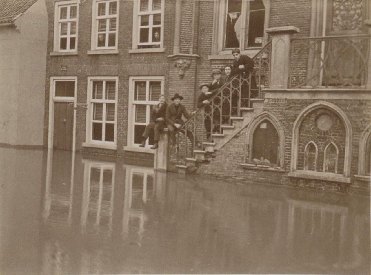 People stand on the steps of the town hall in Cuijk when the streets are flooded