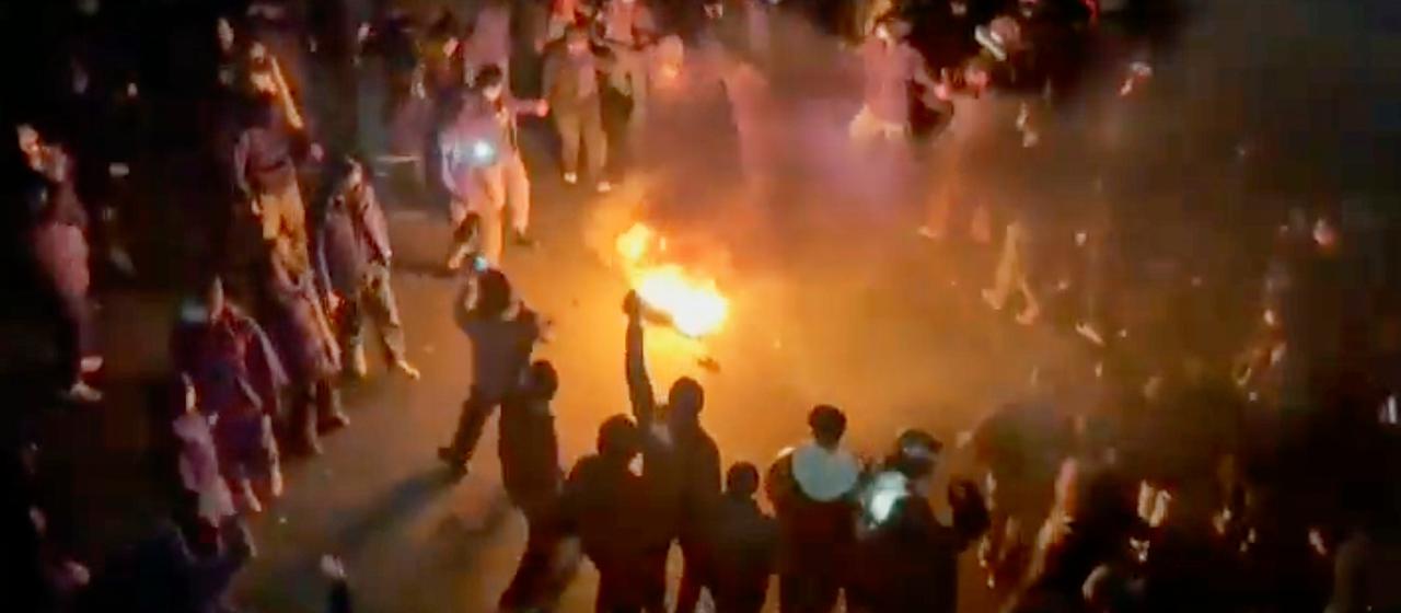 Protesters in Iran dancing around a bonfire 