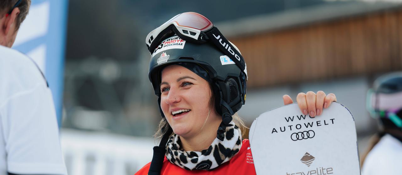 Ramona Hofmeister, laughing with her snowboard in her hand