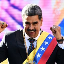 Venezuela's President Nicolás Maduro gestures to his supporters after giving a speech in front of the Miraflores presidential palace in Caracas. Maduro, in power since 2013, was sworn in for a third term despite global outcry that caused thousands to come out to protest on the eve of the ceremony. | Photo:Federico Parra / AFP