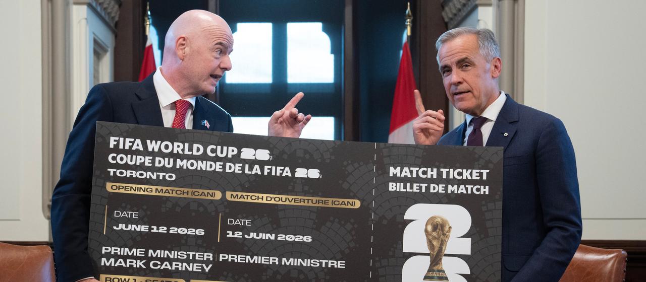   Mark Carney (r.) receives a World Cup ticket from FIFA President Gianni Infantino (l.).