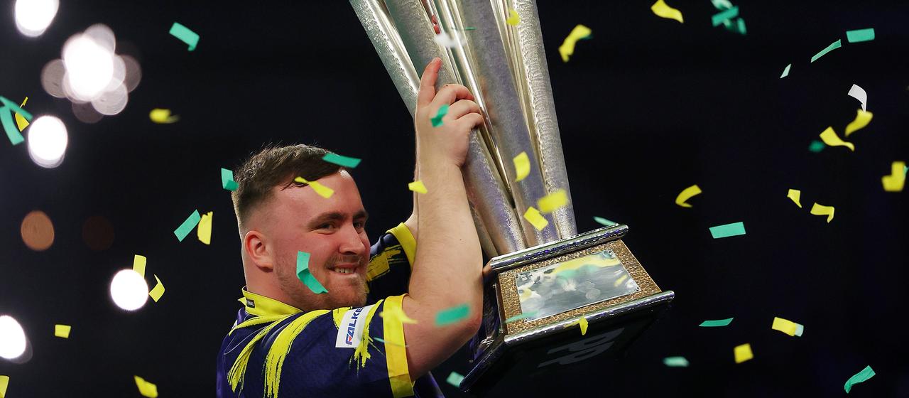 Luke Littler holds up the World Cup trophy