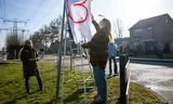 Suzie Klapwijk, organizer of the peace march, and a participant hang up a banner with a heart drawing during the peace march against negative reactions to the proposed location of an asylum seekers' center in Nieuw-Lekkerland.