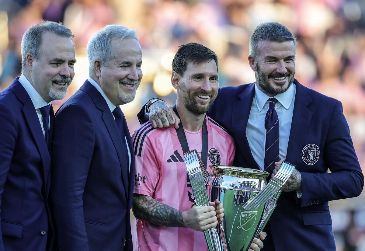 The owners and directors of Inter Miami, Jose Mas, Jorge Mas and David Beckham pose with Lionel Messi and the MLS champions trophy