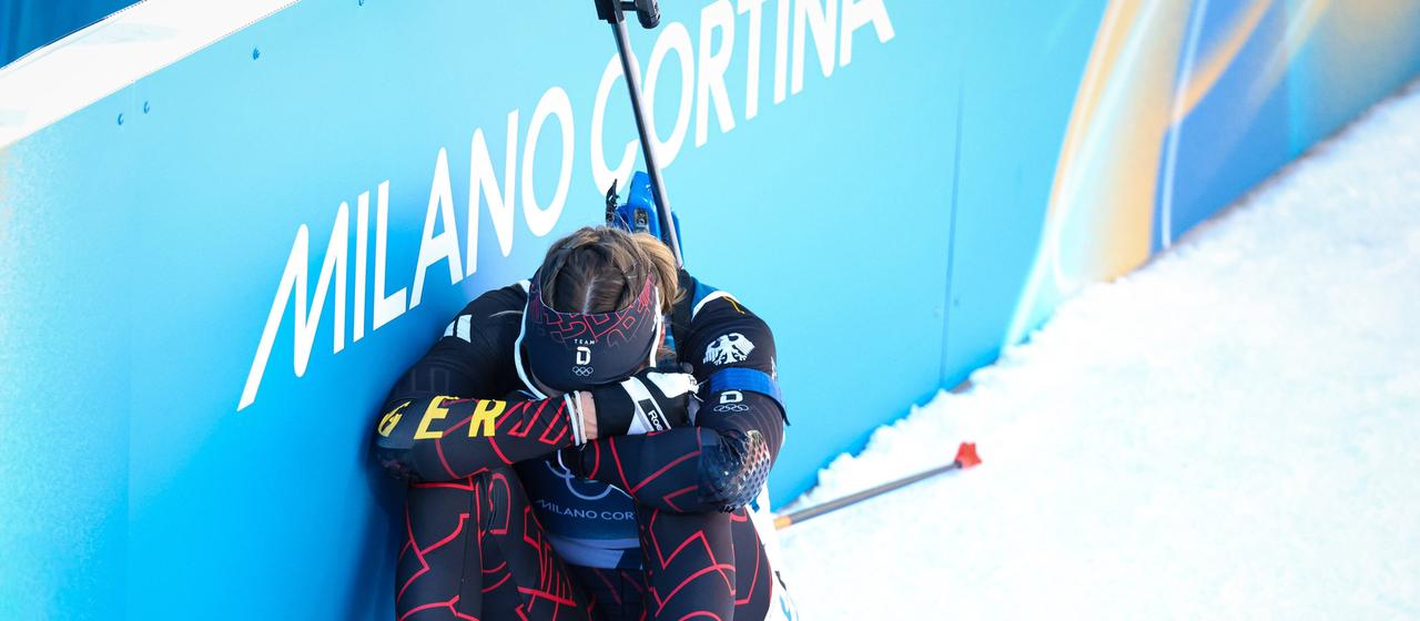 Germany's biathlete Franziska Preuß sits dejectedly on the boards