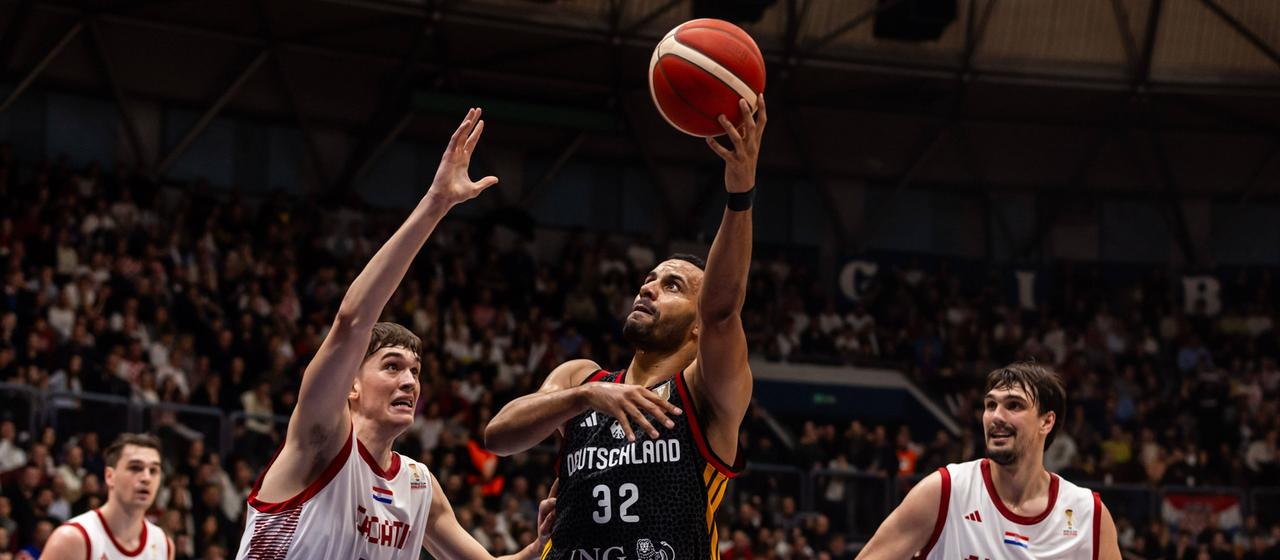 Germany's Johannes Thiemann (number 32) moves to the Croatian basket