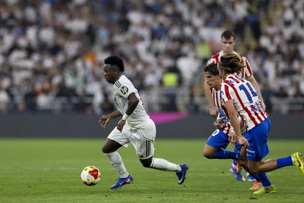 JEDDAH (SAUDI ARABIA), 01/08/2026.- Real Madrid forward Vinícius Jr (i) disputes a ball with Atlético de Madrid players Marcos Llorente (d) and Giuliano Simeone (2d) during the semi-final of the Spanish Super Cup between Atlético de Madrid and Real Madrid, this Thursday at the King Abdullah Stadium, in Jeddah. EFE/Kai Forsterling