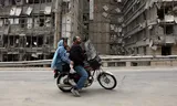 Motorcyclists at the destroyed Gandhi Hospital in Tehran. The hospital was hit on Sunday during air raids by Israel.