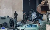 Israeli soldiers cover the site where a Border Police officer shot dead two Palestinian militants in Jenin, the occupied West Bank.