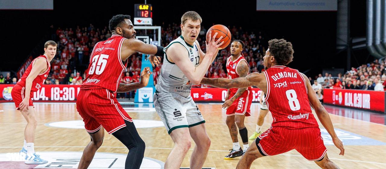 Marten Linßen with the ball against Bamberg's Ejiofor Onu and Demarcus Demonia.
