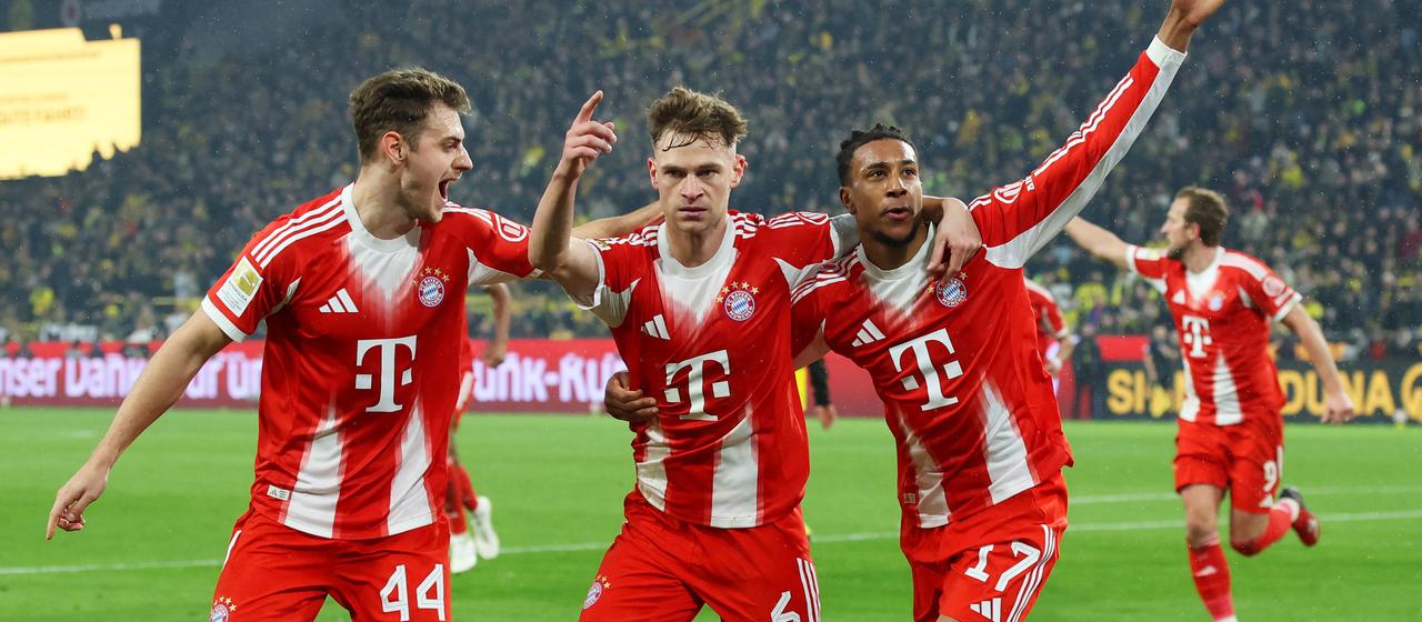 Joshua Kimmich (m.) celebrates his goal in Dortmund with his Bayern teammates Josip Stanisic (l.) and Michael Olise.